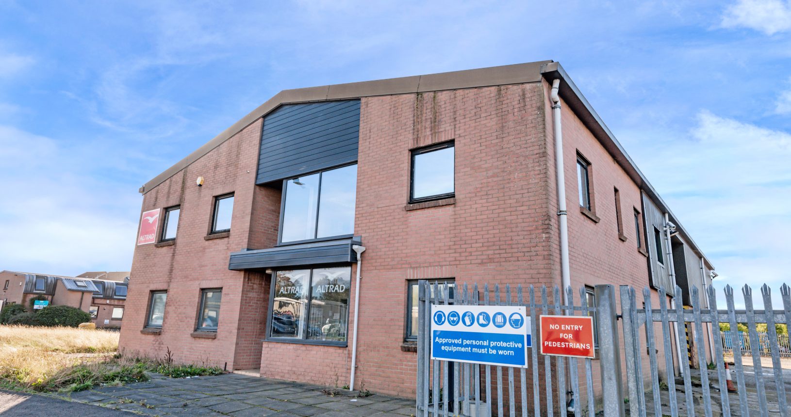 Two-storey brick industrial and office building at Mill Road Industrial Estate in Linlithgow, featuring large front windows, gated access, and private forecourt.