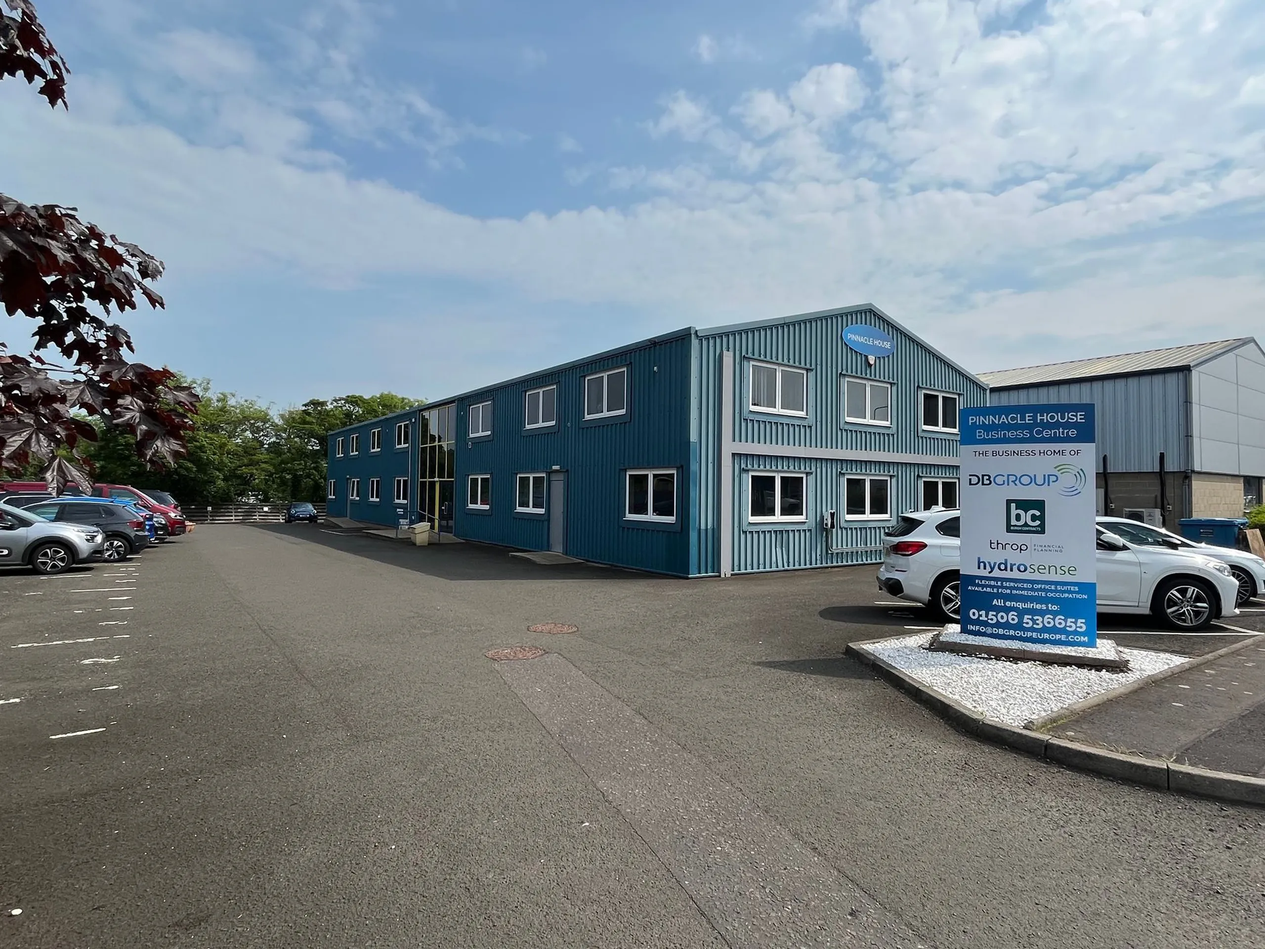 Exterior view of Pinnacle House at Mill Road Industrial Estate in Linlithgow, showing a blue two-storey business centre with on-site parking.