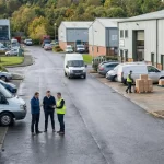 Flexible business premises at Mill Road Industrial Estate showing people working outside industrial units with vans and active operations in Linlithgow