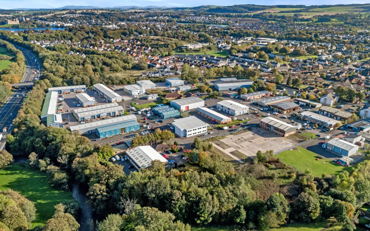 Aerial view of an industrial estate Linlithgow showing Mill Road Industrial Estate with surrounding businesses, road access, and green landscape.